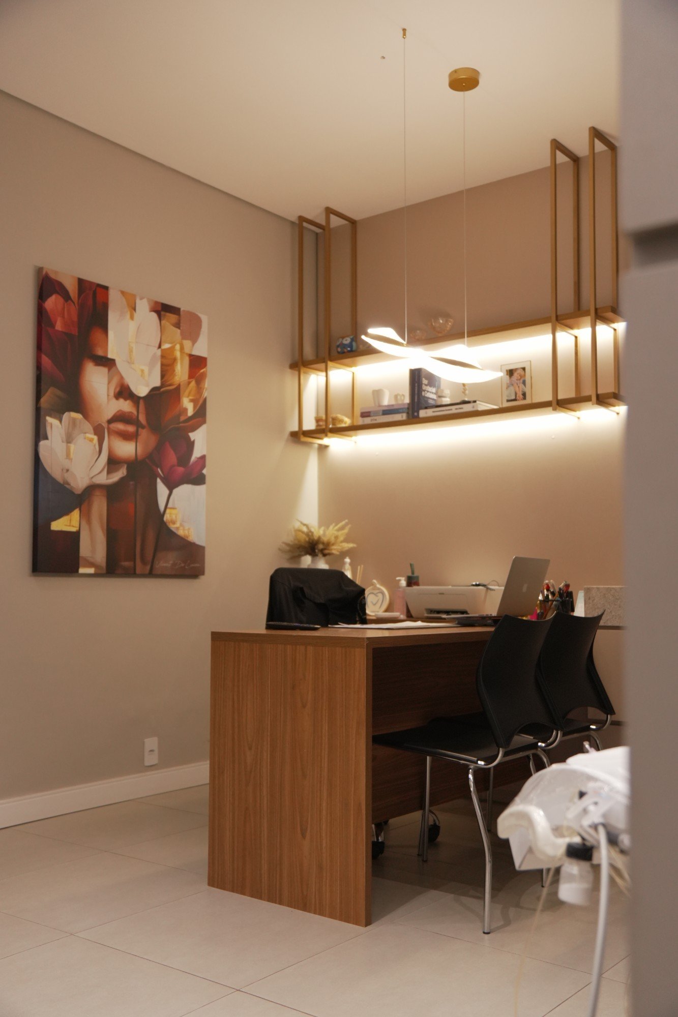 Sala de consulta com mesa, quadro e estante iluminada.
