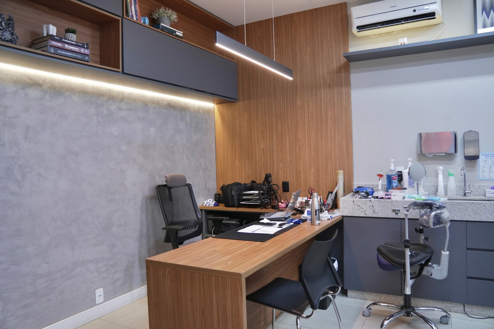 Consultório com mesa de atendimento e livros de endodontia.