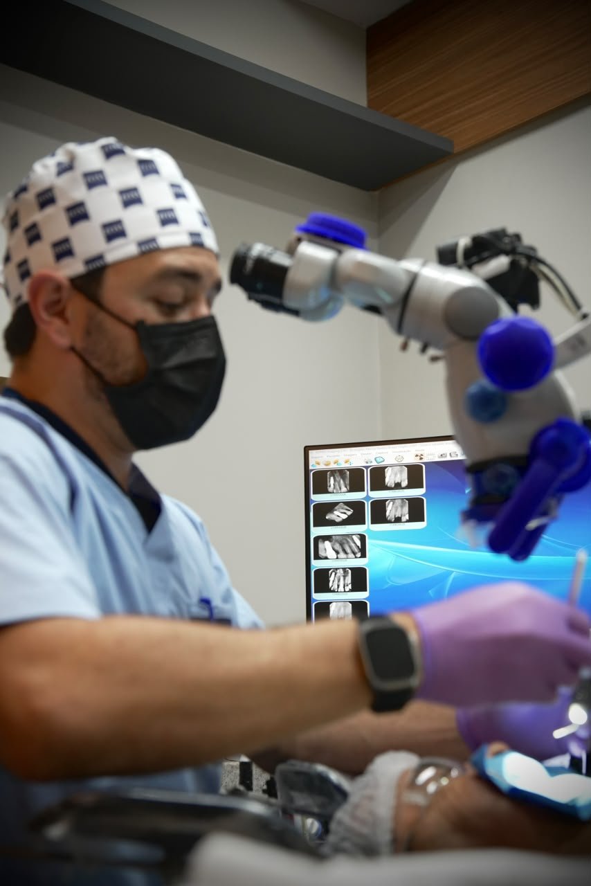 Dr. Virgílio Bastos atendendo com o microscópio odontológico.